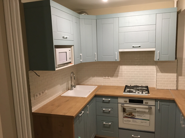 Установлены шкафы, закреплены фасады, смонтирована столешница, подключены бытовые приборы, установлена мойка, смеситель, выполнена отделка фартука. Все элементы собраны и выровнены.