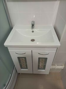 Изображение ванной комнаты с установленной раковиной и смесителем. На стене над раковиной закреплено зеркало, обеспечивающее комфортное использование.