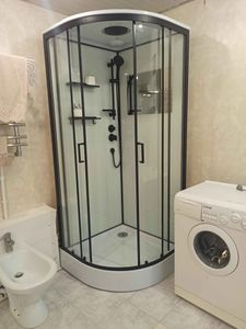 Установлена современная душевая конструкция с прозрачными стенками и черной фурнитурой. Обновлены коммуникации, добавлены полки для удобства, обеспечена герметичность и функциональность.