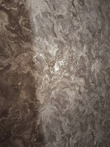 На стене аккуратно размещены фотообои с мраморным узором, создающим эффект глубины и текстуры. Швы тщательно выровнены, поверхность гладкая, без пузырей и складок.