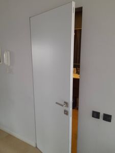 Выполнен монтаж потайной двери: установлена конструкция, скрытая в стене, с ровной отделкой и незаметными петлями. Дверь гармонично вписывается в интерьер, обеспечивая эстетичный вид.