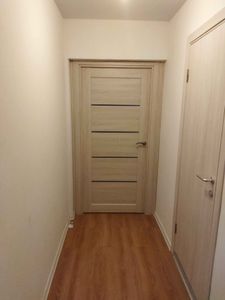 Изменен размер проема, установлена новая дверь, добавлены наличники, обновлены стены и пол, завершена отделка, улучшена эстетика коридора.