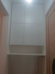 Установлена полка под шкафом, закреплена на стене с помощью кронштейнов. Работа завершена аккуратно, конструкция устойчива, обеспечивает дополнительное место для хранения.