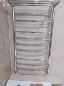 Закреплен новый хромированный полотенцесушитель на стене ванной комнаты, подключены трубы к системе водоснабжения, проверена герметичность соединений, обеспечена надежная фиксация.