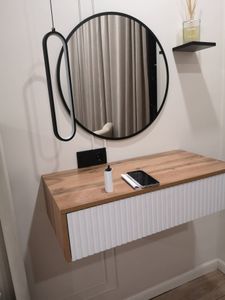 На стене закреплена небольшая полочка, выполненная из темного дерева. Она надежно установлена, идеально выровнена и готова к использованию.