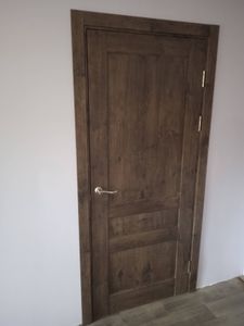 Установлена деревянная створка, закреплены петли, врезана ручка, выровнена коробка, проведена регулировка, проверена плавность открывания и закрывания, завершена отделка наличниками.