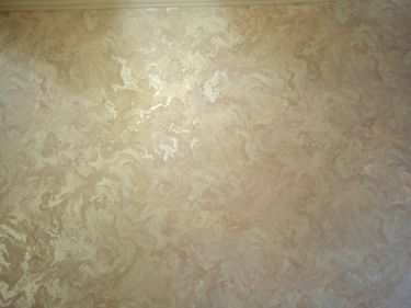 На стену нанесены фотообои с мраморным узором, создающим эффект текстуры. Поверхность ровная, без видимых швов, что обеспечивает целостный вид и гармонию в интерьере.