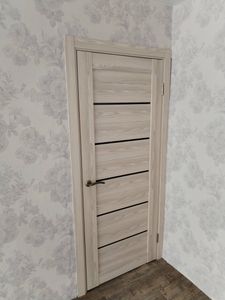 Изображена установленная дверь-гармошка. Проведены работы по монтажу конструкции, закреплены направляющие, установлены петли, ручка, обеспечена плавная работа механизма.