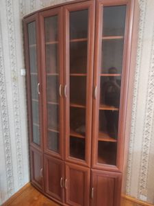 Собран шкаф: установлены полки, закреплены дверцы, прикручены ручки, выровнена конструкция, проверена устойчивость. Все элементы надежно зафиксированы, обеспечена функциональность.