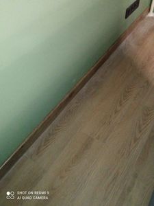 Установлен декоративный элемент вдоль стены, обеспечивающий плавный переход между полом и стеной. Подобран материал, подходящий по цвету и текстуре, обеспечена надежная фиксация.