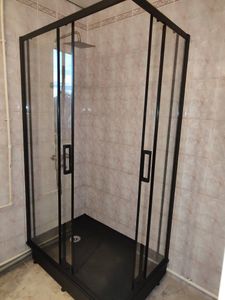 Установлена стеклянная конструкция с черными рамами, закреплены двери, подключен душевой лейка, герметизация швов, проверена устойчивость, произведена настройка всех элементов.