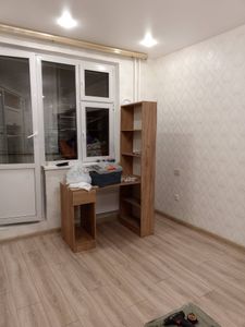 На полу уложен ламинат, создающий ровное и аккуратное покрытие. Плинтусы установлены по периметру, завершая оформление интерьера.