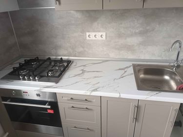 Установлена новая столешница из ДСП, врезана варочная панель, раковина. Все элементы плотно закреплены, швы герметично обработаны. Поверхность ровная, готова к использованию.