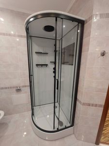 Установлена новая душевая конструкция: закреплены стеклянные панели, подключены водопроводные элементы, герметизированы швы, проверена работа сливной системы, добавлены полки для удобства.