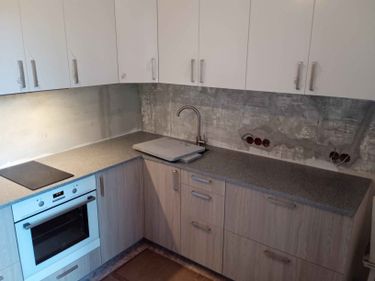 Установлена новая поверхность из искусственного камня, вырезаны отверстия для варочной панели и мойки, закреплены шкафы, подключен смеситель, проведены все необходимые монтажные работы.