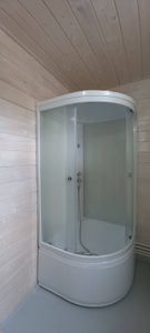 Смонтирована новая кабина: установлены стеклянные двери, закреплены панели, подключен смеситель, подсоединён слив, герметизация швов, проверена герметичность, завершена отделка.