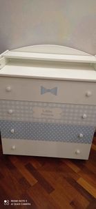 Собран белый комод с тремя ящиками, украшенными голубыми узорами и надписью "Little Prince". Установлены ручки, выровнены фасады, проверена устойчивость конструкции.