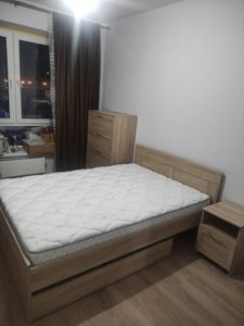 Собран новый деревянный шкаф с четырьмя ящиками, установлен в спальне. Все детали надежно закреплены, фасады выровнены, ручки прикручены, обеспечена функциональность и эстетика.