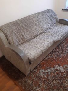 Собран диван: установлены каркас, подлокотники, спинка и сиденье. Проверена устойчивость конструкции, закреплены все элементы. Готов к использованию, стоит на ковре.