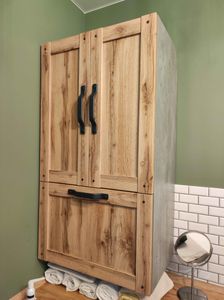 Установлен деревянный шкаф с металлическими ручками на стене, выполнена отделка в стиле под дерево, добавлены декоративные элементы, обновлён интерьер помещения.