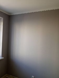 На стену аккуратно нанесен стеклохолст, поверхность ровная и гладкая, без видимых дефектов. Углы и стыки обработаны тщательно, создавая целостный и завершенный вид.