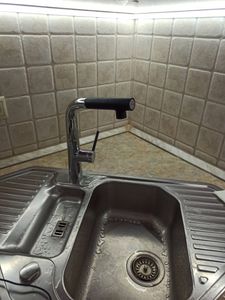 Установлен новый кран на кухонную мойку. Подключены водопроводные шланги, проверена герметичность соединений, устранены протечки. Обновлён внешний вид рабочей зоны.