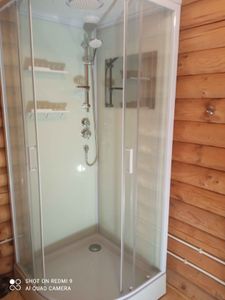 Установлена современная душевая конструкция с прозрачными стенками, герметично закреплена, подключены водопроводные коммуникации, смонтированы полки и душевой гарнитур.