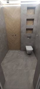 Выполнена обработка швов между плитками в ванной комнате, обеспечивающая герметичность и эстетичный вид. Использованы материалы, подходящие по цвету и текстуре к поверхности.