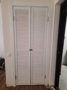 Установлены двустворчатые двери, закреплены петли, отрегулированы створки, проверена плавность открывания, добавлены ручки, завершена отделка проема, обеспечена надежная фиксация конструкции.