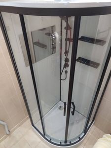 Установлена душевая с низким поддоном: смонтированы стеклянные панели, закреплены дверцы, подключены коммуникации, проверена герметичность соединений, установлены полки и держатели.