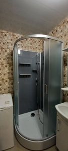 Изображение ванной комнаты с душевой кабиной, стиральной машиной и раковиной. Установка завершена, подключены коммуникации, проверена работа, обеспечена герметичность соединений.