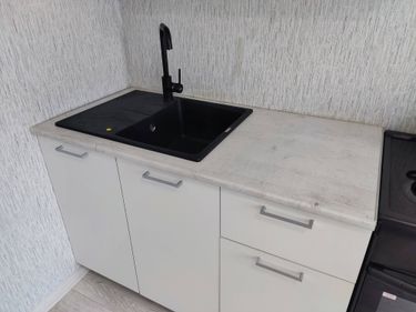 Установлена новая столешница из ДСП, выполнены вырезы под раковину и смеситель, закреплены крепежи, герметизированы стыки, проверена устойчивость и функциональность конструкции.