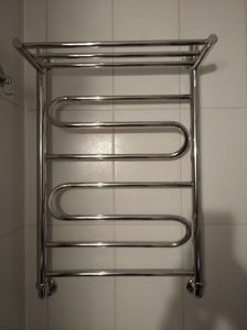 Установлен водяной полотенцесушитель на стену, подключены трубы к системе водоснабжения, проверена герметичность соединений, проведены испытания на работоспособность, завершена отделка.