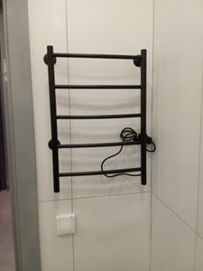 На стене закреплена металлическая конструкция с проводом, рядом выключатель. Установка завершена, все элементы надежно зафиксированы, обеспечивая функциональность и безопасность.