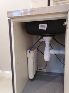 Установлено устройство для переработки отходов под раковиной, подключены трубы и электричество, проверена герметичность соединений, обеспечена функциональность системы.