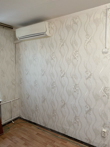 На стенах аккуратно размещены обои с изящным узором, создающим гармоничный интерьер. Поверхность ровная, без видимых швов и дефектов, что придаёт помещению завершённый вид.