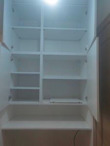 Установлены белоснежные шкафы с полками, закреплены петли, дверцы ровно навешены, обеспечена прочная фиксация, внутренние секции выровнены, завершена сборка, обеспечена функциональность.