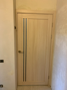 Выполнена установка замка в деревянную дверь: вырезано отверстие, закреплен механизм, установлены ручки, проверена работа. Дверь закрывается плавно, без заеданий, все элементы на месте.