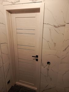 Установлен новый замок в дверное полотно. Выполнены точные вырезы для механизма и ручки. Все элементы надежно закреплены, обеспечивая плавное открытие и закрытие.