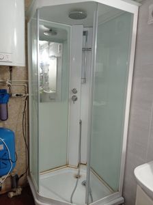 Установлена новая кабина: закреплены стенки, поддон, двери, подключены водопроводные шланги, герметизация швов, проверка работы смесителя и душа, завершение монтажа.