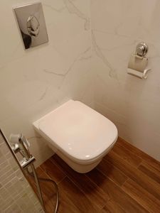 Закреплено сантехническое оборудование на стене, подключены коммуникации, установлена кнопка смыва, проведена облицовка плиткой, обеспечена герметичность соединений.