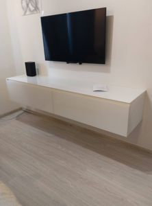 Собрана белая подвесная тумба с ящиками. Установлены направляющие, закреплены фасады, проверена плавность выдвижения. Готовая конструкция надежно закреплена на стене.