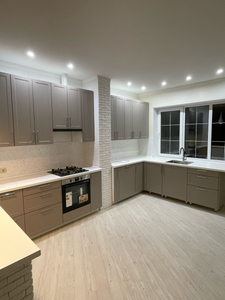 Выполнена подгонка кухонной поверхности, обеспечивающая идеальное прилегание к стенам и мебели, с учетом всех углов и вырезов под технику, что создает гармоничный и функциональный интерьер.