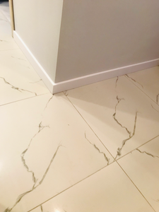 Установлен скрытый плинтус, аккуратно интегрированный в стену, создавая плавный переход между поверхностями. Завершенная работа обеспечивает эстетичный вид и скрывает монтажные элементы.