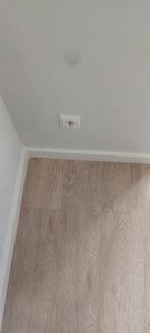 Установлен новый плинтус вдоль стены, аккуратно прилегающий к полу. Завершены все работы по подгонке и креплению, обеспечена ровная линия и плотное прилегание к поверхности.