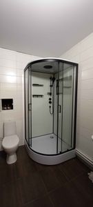 Установлена современная душевая конструкция с гидромассажной системой. Подключены водопроводные коммуникации, закреплены стеклянные панели, смонтированы полки и дверцы.