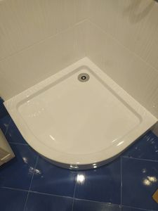 Установлен слив в полу под плитку, обеспечена герметичность, выровнено основание, подключена канализация, уложена плитка, проверена система на утечки, завершены отделочные работы.