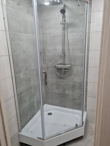 Изображение демонстрирует завершенный монтаж душевой кабины с прозрачными стенками и металлическим каркасом. Установлены смеситель, лейка, поддон, обеспечивающие комфортное использование.