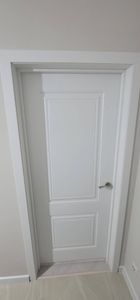 Установлена новая дверь: закреплены петли, врезан замок, отрегулирована коробка, добавлены наличники. Все элементы подогнаны, обеспечена плавная работа, эстетичный вид завершен.