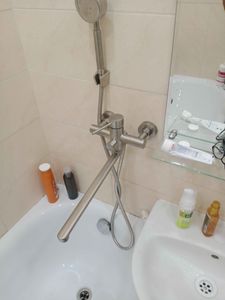 Изображение демонстрирует установленный новый смеситель с душевой лейкой в ванной комнате. Все элементы надежно закреплены, обеспечивая функциональность и эстетичный вид.